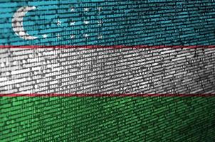 la bandera de uzbekistán se representa en la pantalla con el código del programa. el concepto de tecnología moderna y desarrollo de sitios foto