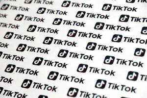 ternopil, ucrania - 2 de mayo de 2022 muchos logotipos de tiktok impresos en papel. tiktok o douyin es un famoso servicio chino de alojamiento de videos de formato corto propiedad de bytedance foto