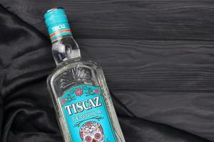 KHARKIV, UKRAINE - NOVEMBER 3, 2021 Tiscaz tequila alcohol bottle with traditional mexican pattern and art design on glass surface. photo