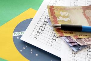 Pen with Brazilian money bills on blank of lottery game. Concept of luck and gambling in Brazil photo