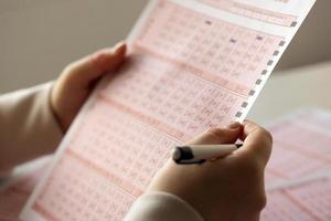 Filling out a lottery ticket. A young woman plays the lottery and dreams of winning the jackpot photo