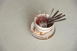 Stack of dirty dishes with food leftovers on the table after meal. Banquet ending concept. Unwashed dishes photo