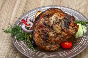 rodilla de cerdo en el plato y fondo de madera foto