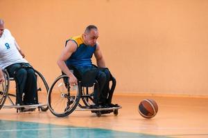 veteranos de guerra discapacitados en acción mientras juegan baloncesto en una cancha de baloncesto con equipo deportivo profesional para discapacitados foto