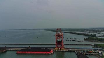 excavatrices d'équipement lourd transportant du charbon en mer à partir de barges pour les compagnies d'électricité. vue aérienne. video