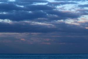 Large rain clouds in the sky over the sea. photo