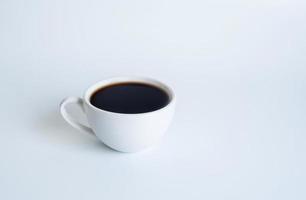 fotografía de la vista superior de la taza de café con leche en un plato blanco el interior del vaso parece vacío. esperando que se rellene el café caliente para beber para sentirse renovado y alerta sobre un fondo blanco. foto