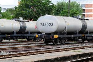 Many of the oil tankers in the freight train are parked in the railway yard. photo