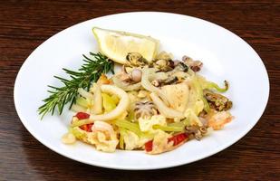 Seafood cocktail on the plate and wooden background photo