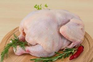 Raw chicken on wooden board and wooden background photo