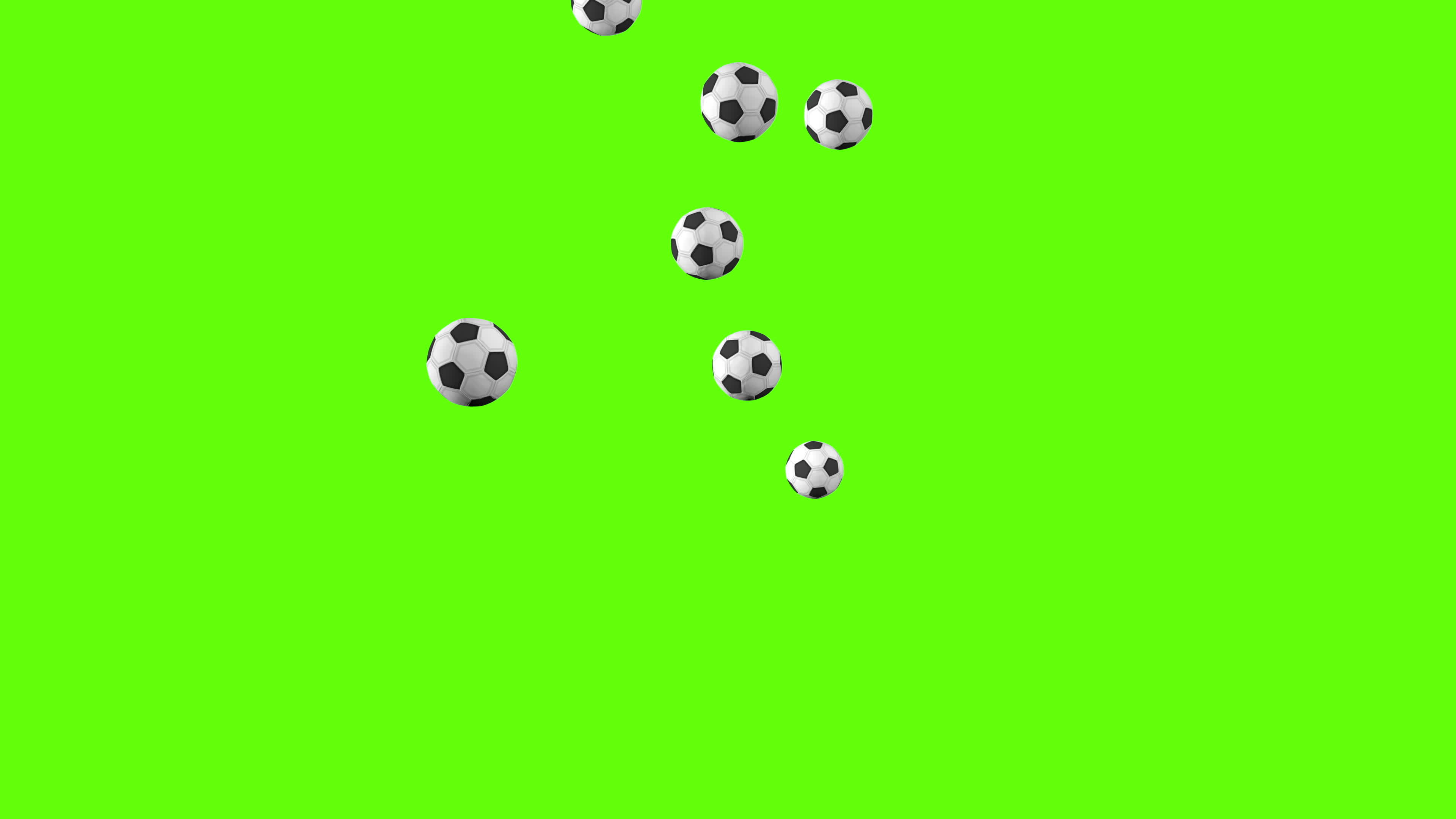 Group of black and white soccer balls bouncing on a green surface