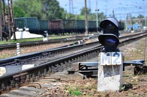 Railway traffic light semaphore against the background of a day railway landscape. Signal device on the railway track photo