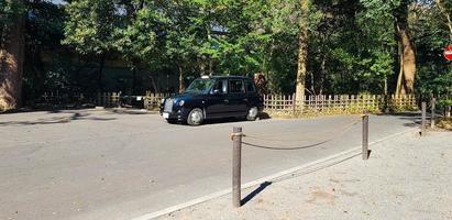 japón en abril de 2019. un automóvil negro con un modelo antiguo está estacionado en el santuario meiji. foto