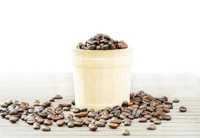 Coffee beans in wood bucket on white photo