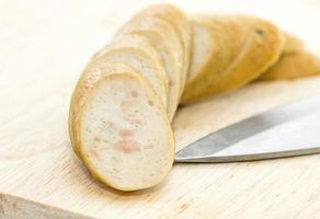 Sausage with knife over cutting board photo