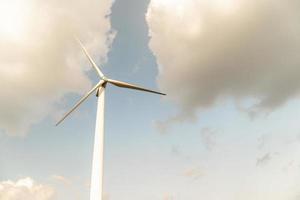 Wind turbine against a cloudy blue sky photo