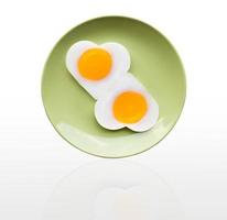 Fried egg heart on green dish photo