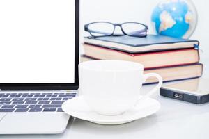 Laptop mockup and coffee cup on table photo