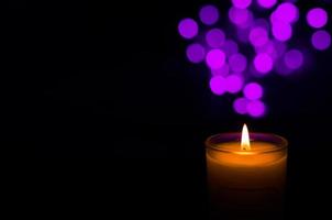 Aromatic candle with flame and round shape bokeh on dark background for Thanks giving and Christmas day. photo