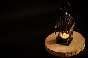 Beautiful Lantern that have moon symbol on top put on wooden tray with dark background. photo