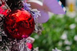 Red bauble and lights decorate on Christmas tree that have fake snow on it. photo
