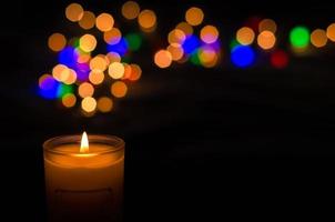 Aromatic candle with flame and round shape bokeh on dark background for Thanks giving and Christmas day.