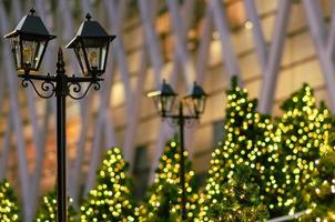 Lantern with blurred colorful Christmas tree in background for Christmas holiday festival. photo