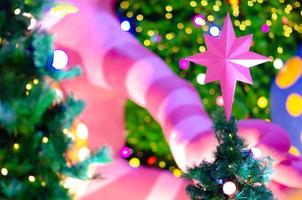 Star ornament puts on top of Christmas tree for Holiday decoration with colorful lights on background. photo