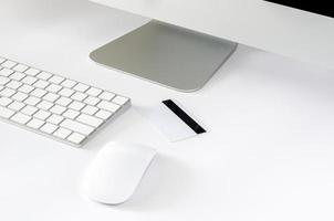 la tarjeta de crédito se coloca en el escritorio con mouse inalámbrico, teclado y pantalla de computadora para comprar en línea y el concepto de lunes cibernético. foto