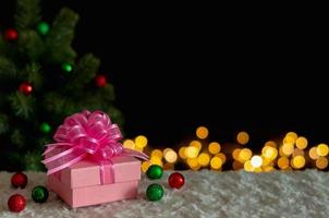 caja de regalo y adornos con árbol de navidad y fondo de luces. concepto de navidad y año nuevo. foto