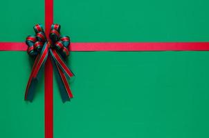 cinta de navidad con lazo sobre fondo verde. concepto de navidad y año nuevo. foto