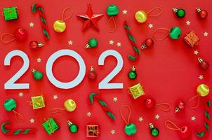 New year ornament decorations with number of the year and empty space on red background. Flat lay minimal Holiday concept. photo