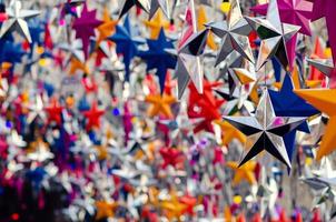 coloridos adornos de estrellas colgando para decorar para las vacaciones de navidad. foto