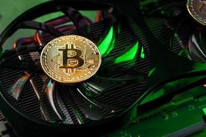 On the powerful fans of the video card there are coins of the Bitcoin cryptocurrency with a green backlight photo