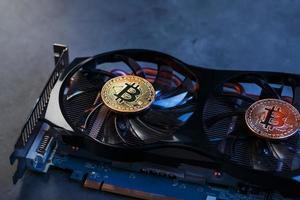 Bitcoin on a graphic card with a blue neon light on a dark background. photo