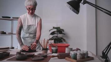 femme âgée asiatique appréciant le travail de poterie à la maison. une céramiste féminine fabrique de nouvelles poteries dans un studio video