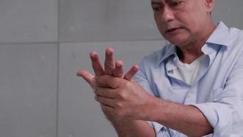 un homme asiatique a des picotements et un engourdissement dans la main qui causent le béribéri. video