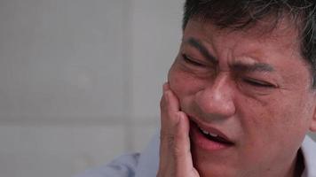 asiatisk senior man lidande från tandvärk. video