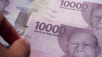 Hand zählen 10000 und 50000 Rupiah Geld. Rupiah ist die offizielle Zahlungswährung in Indonesien. video