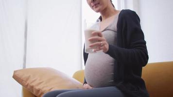 une femme enceinte asiatique heureuse mange des aliments sains pour son bébé à naître. video