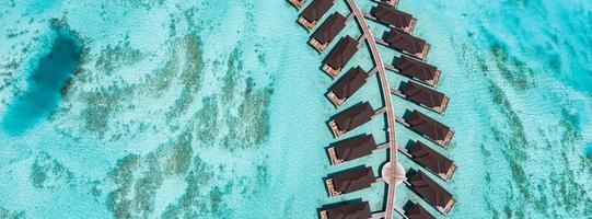 paisaje aéreo perfecto, resort tropical de lujo con villas de agua. hermosa playa de la isla, palmeras, cielo soleado. increíble vista de pájaro en maldivas, costa del paraíso. turismo exótico, relax naturaleza mar foto