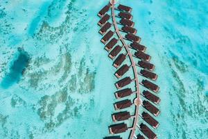 hermoso paraíso de maldivas. paisaje de viaje aéreo tropical, paisaje marino con puente de madera, villas de agua, increíble playa de cielo de arena de mar, naturaleza de isla tropical. turismo exótico destino vacaciones de verano foto