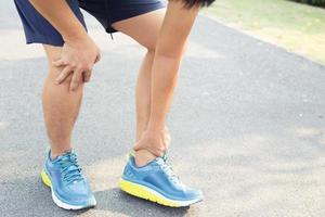 un hombre con dolor de rodilla en el parque foto