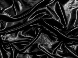 Black satin texture background with liquid wave or wavy folds. Wallpaper design photo