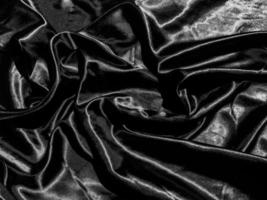 Black satin texture background with liquid wave or wavy folds. Wallpaper design photo