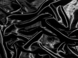 Black satin texture background with liquid wave or wavy folds. Wallpaper design photo