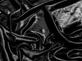 Black satin texture background with liquid wave or wavy folds. Wallpaper design photo