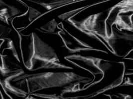 Black satin texture background with liquid wave or wavy folds. Wallpaper design photo