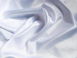 white crumpled fabric texture background. Silk curtain with fold waves for design photo