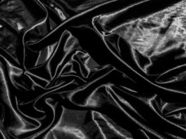 Black satin texture background with liquid wave or wavy folds. Wallpaper design photo